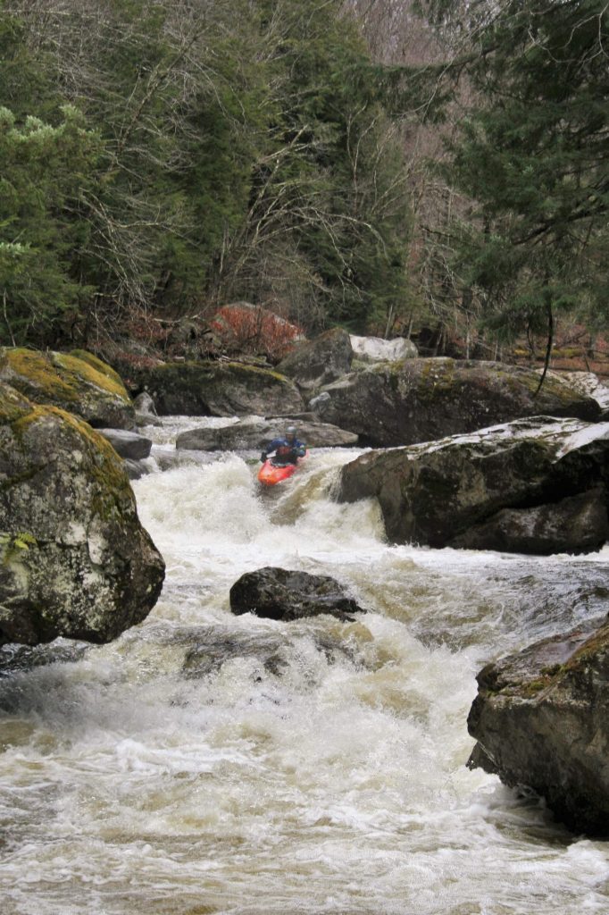 Simone Orlandi runs a boulder garden rapid on the Trout River Vermont Whitewater Kayaking