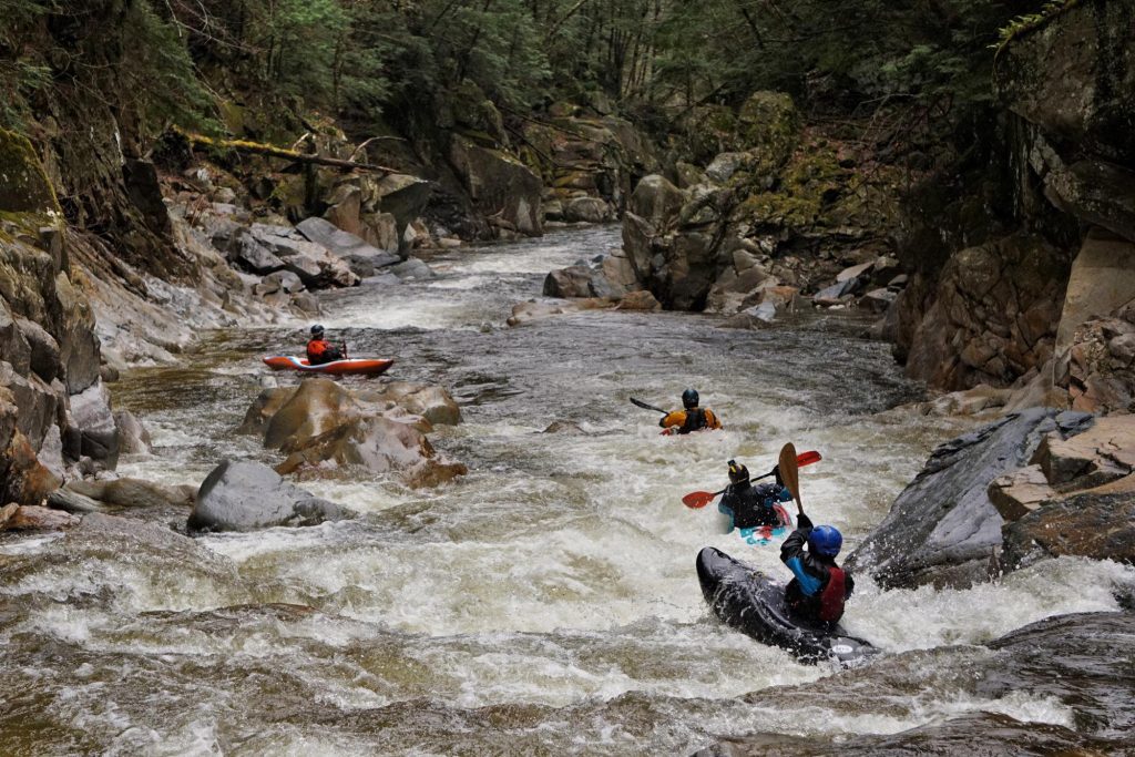 A group of kayakers in the Clarendon Gorge of the Mill River Vermont Whitewater Kayaking