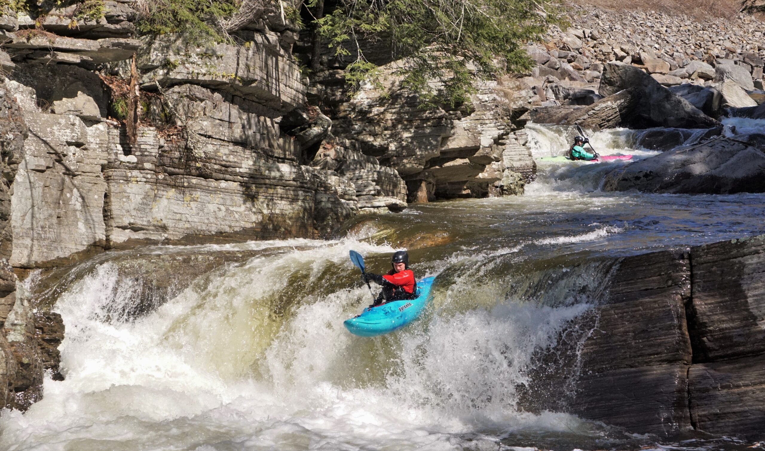 A kayaker runs the rapid All American Boof on the New Haven River Vermont whitewater kayaking